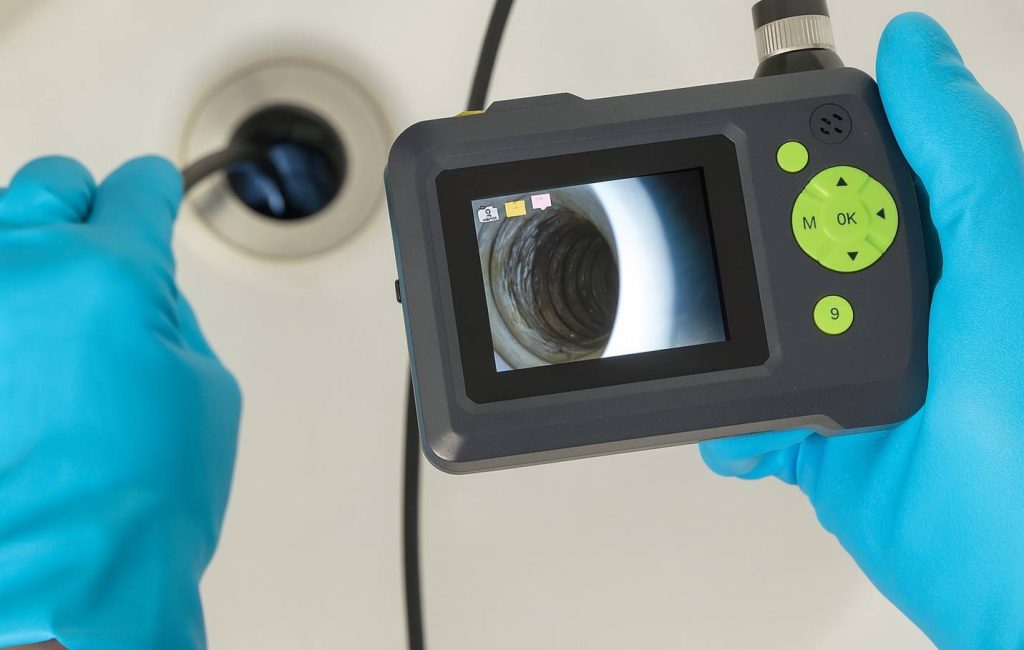 Technician performing a camera inspection for clogged drain solutions.
